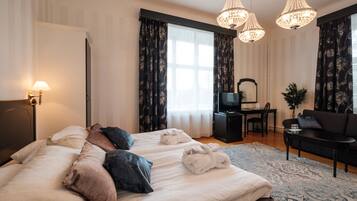 Une chambre d’hôtel avec deux lits, un bureau, une télévision et un canapé.