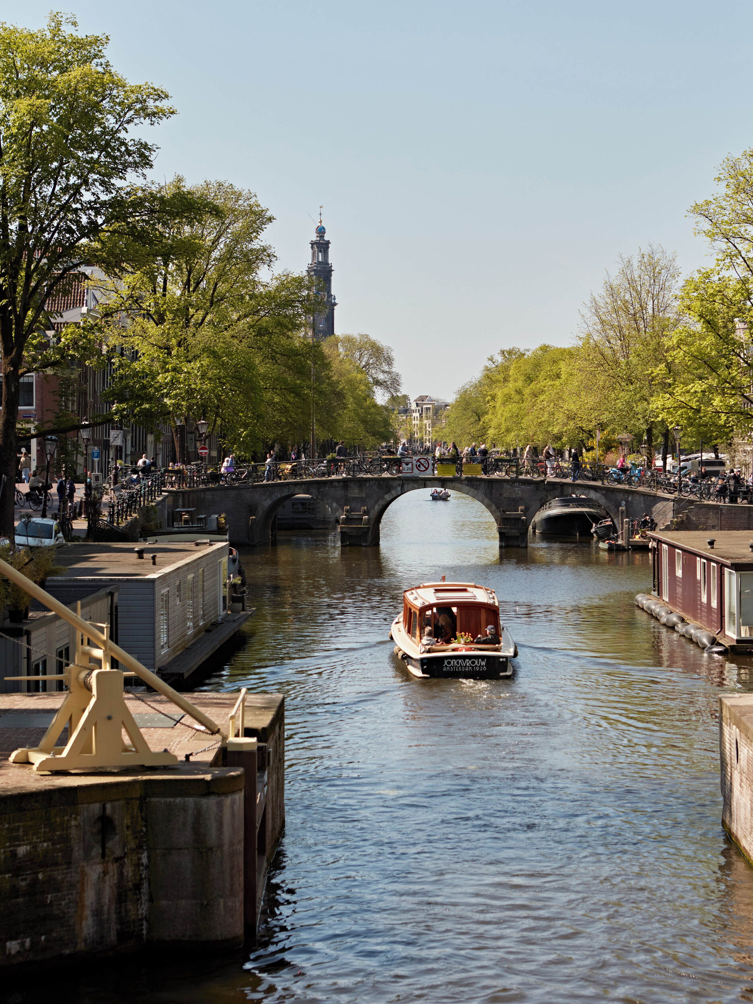 Un canal con un barco, un puente y edificios a lo largo del agua.