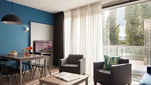 A modern living room with a dining area, a sofa, a coffee table, and a view of the outdoors. - YAYS Amsterdam Prince Island by Numa (Amsterdam)