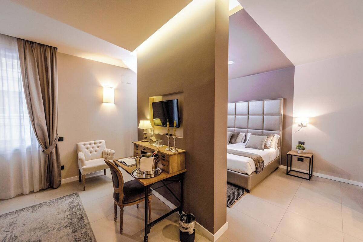 Une chambre d’hôtel comprenant un lit, un bureau avec une chaise, une télévision et une petite table de chevet.