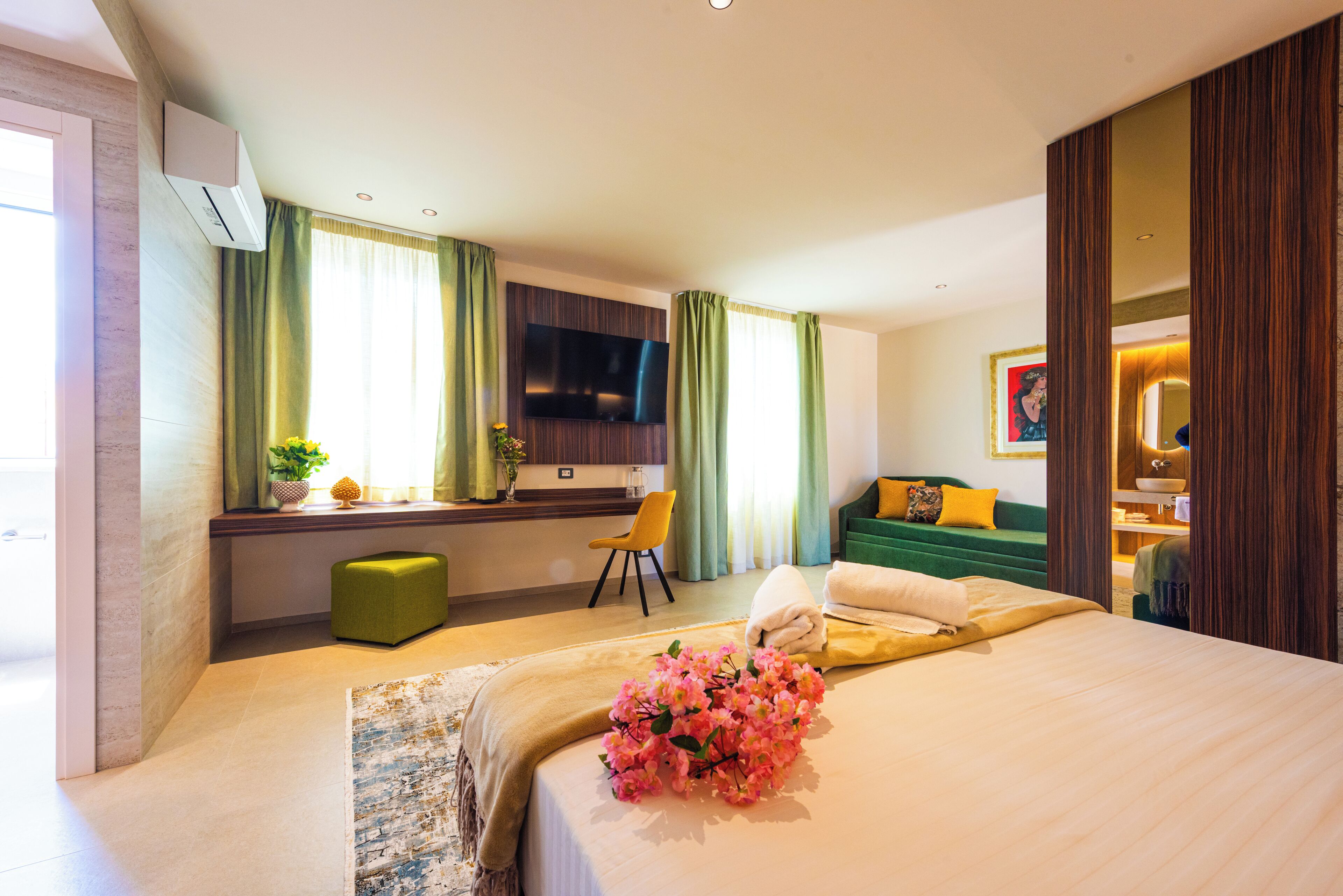 Une chambre d’hôtel comprenant un lit, un bureau, une chaise, une télévision et une salle de bain.