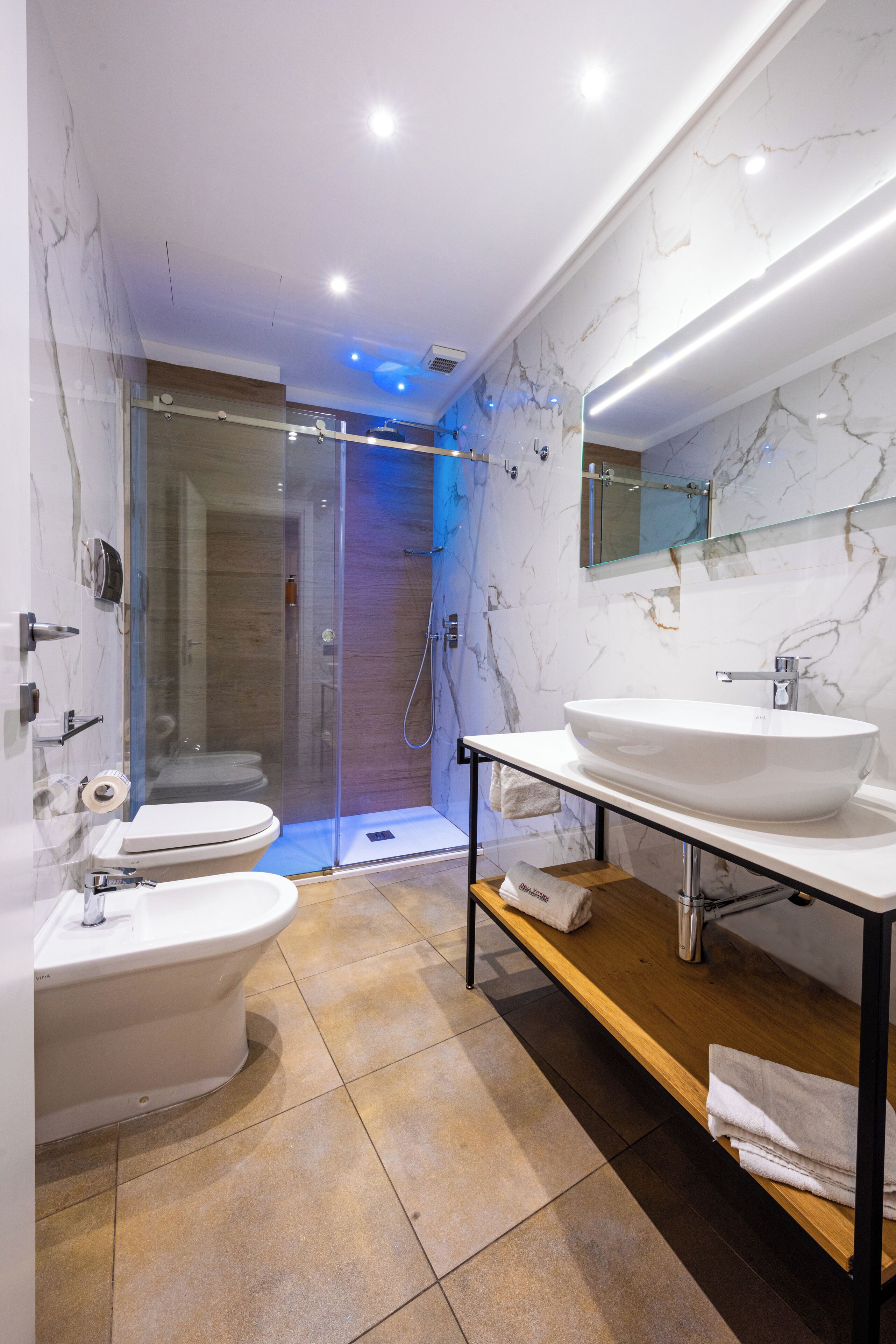 Un baño moderno con ducha de vidrio, inodoro y lavabo con tocador.