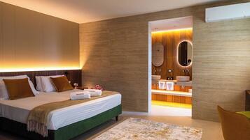 A modern hotel room with a large bed, a bathroom with a vanity and mirror, and a green accent wall.