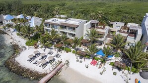 An aerial view of a beachfront resort with multiple buildings, a sandy beach, and palm trees. - Mereva Tulum (Tulum)