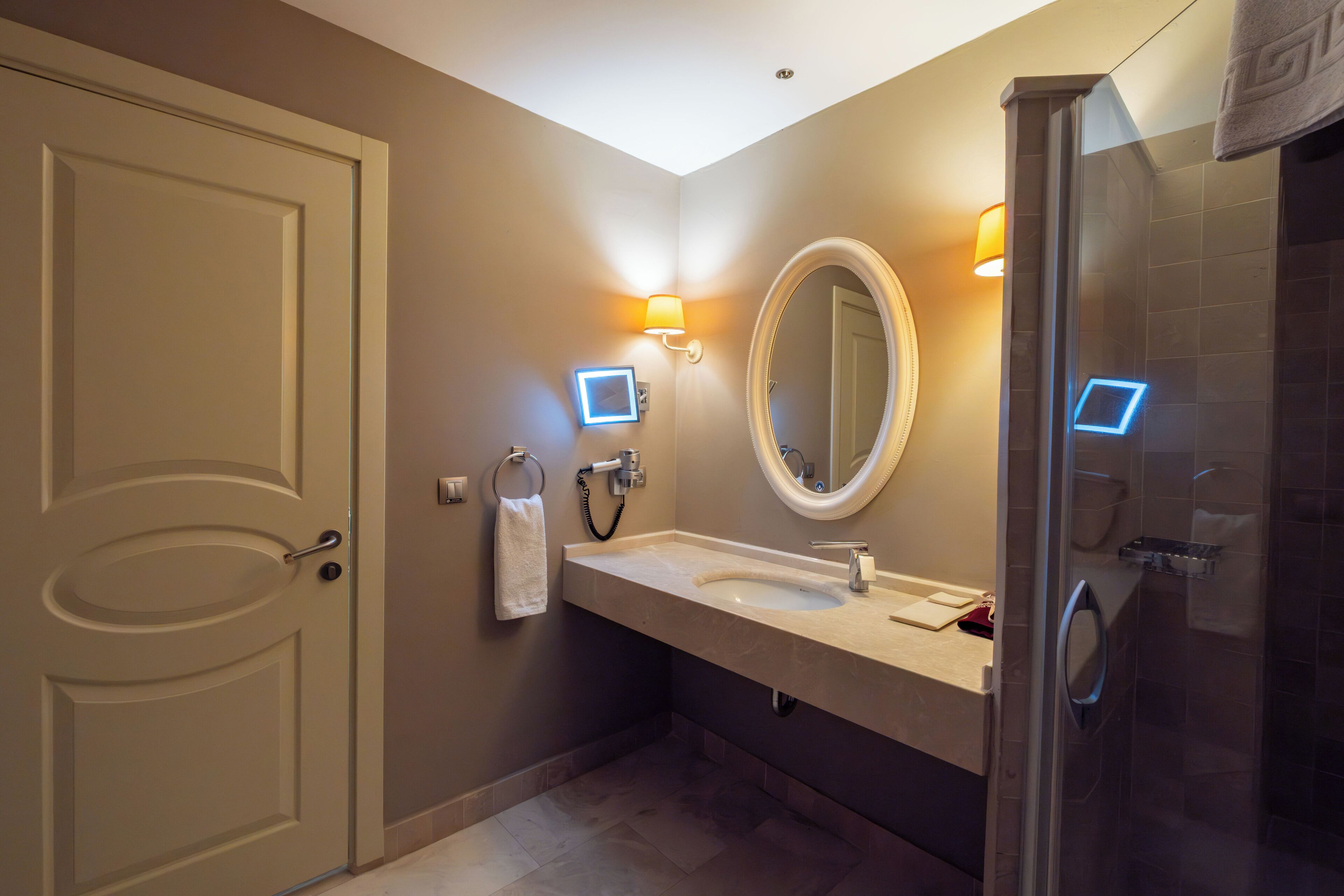 A modern bathroom with a sink, mirror, and shower.