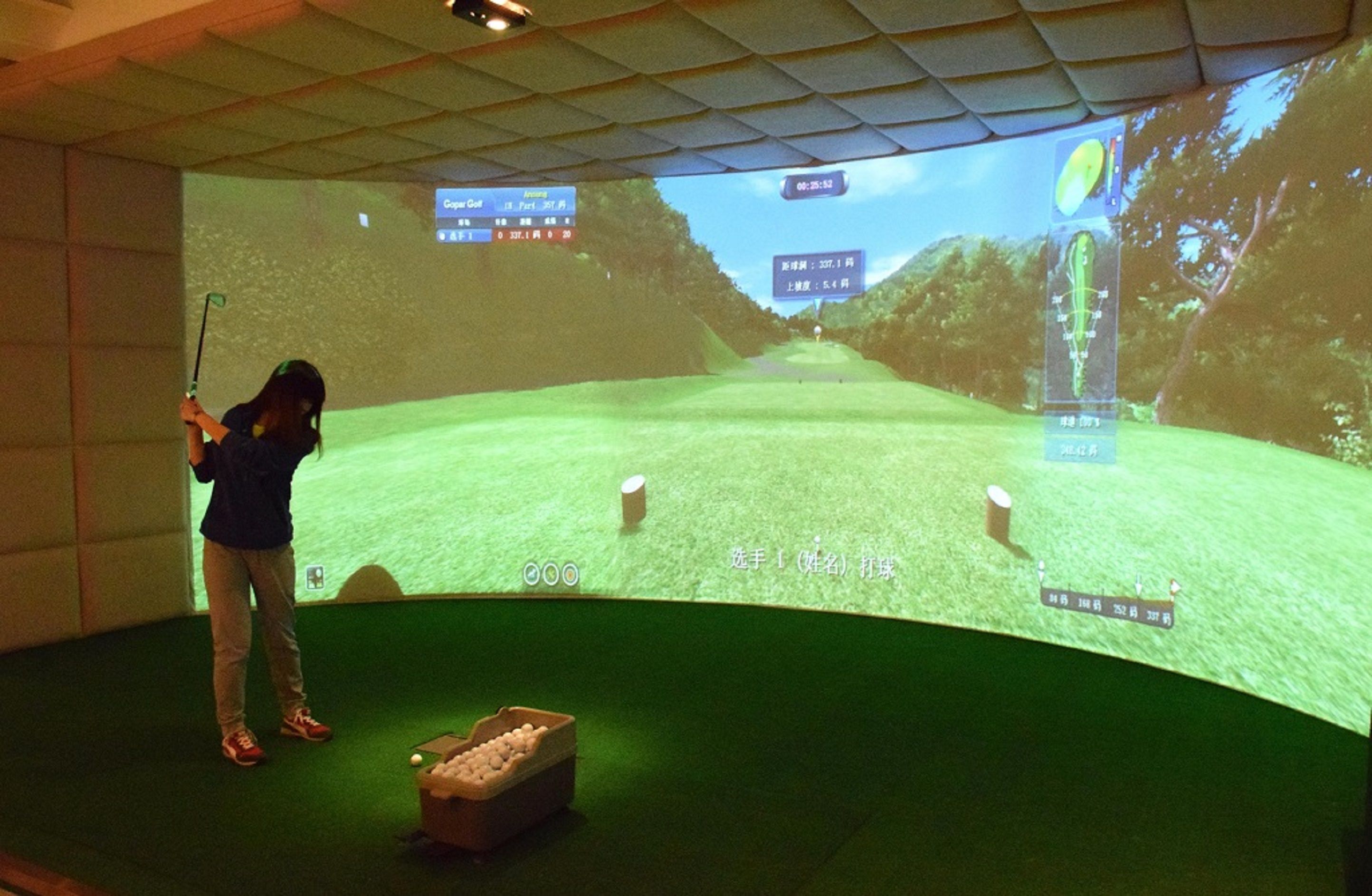 Iemand speelt binnengolf met een projectie van een golfbaan op de muur.