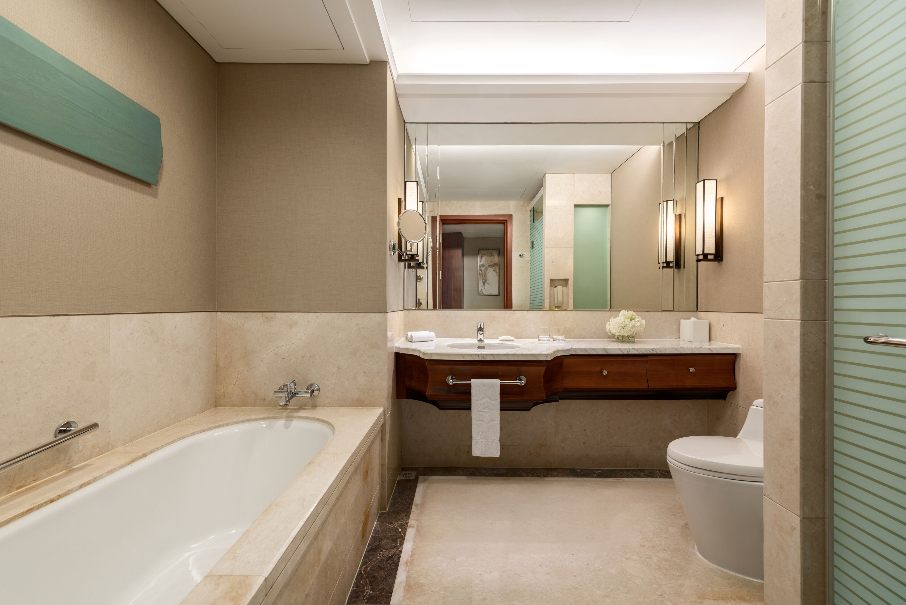 A modern bathroom with a freestanding bathtub, a vanity with a mirror, and a toilet.