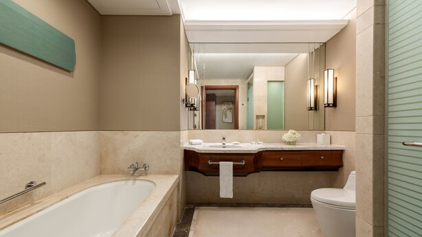 Ein modernes Badezimmer mit einer freistehenden Badewanne, einem Waschtisch inklusive Spiegel und einer Toilette.