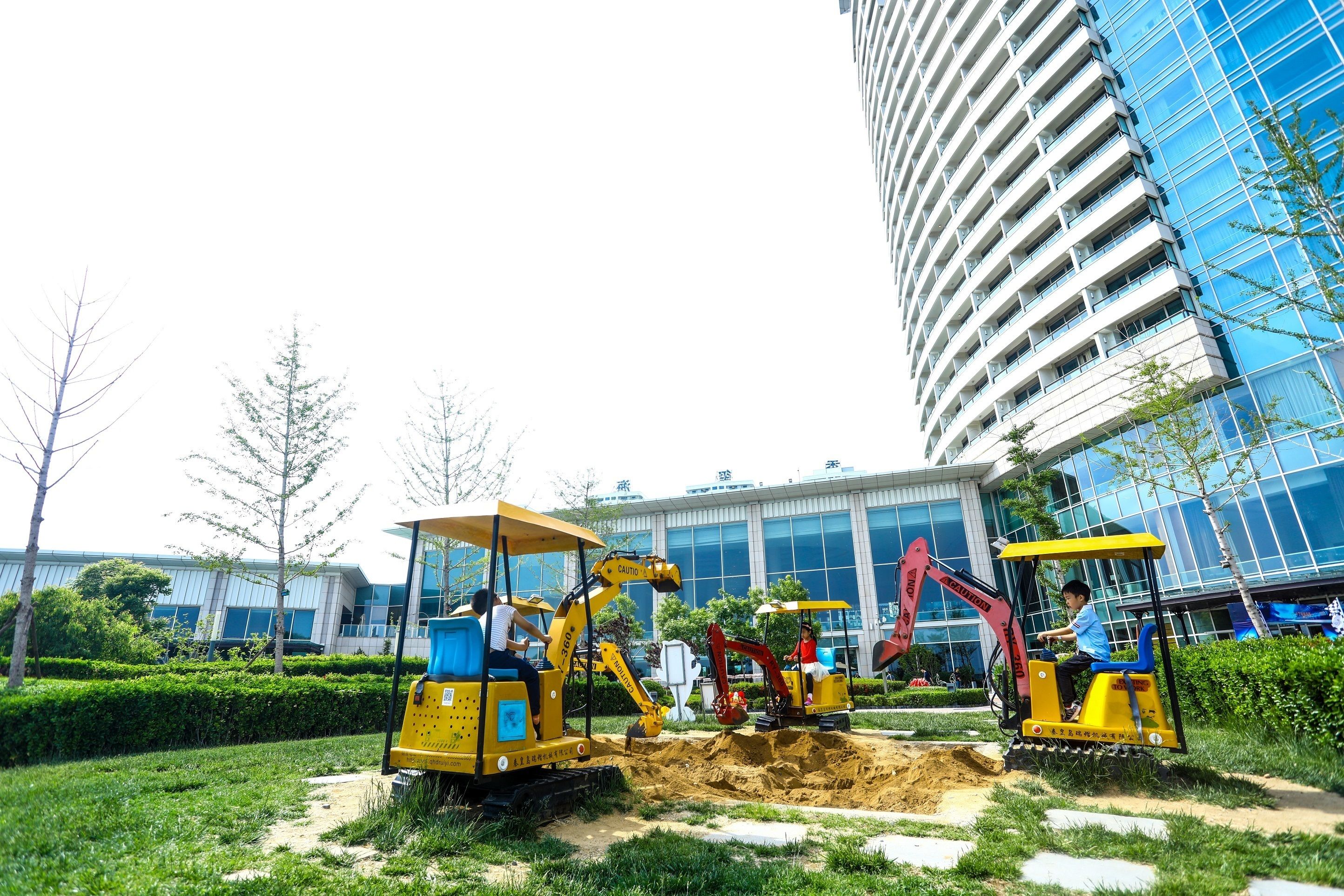 A construction site with heavy machinery in front of a modern building.