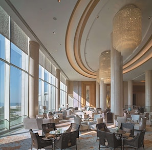 A spacious lobby with high ceilings, large windows, and elegant chandeliers. - Shangri-La Qinhuangdao (Qinhuangdao)