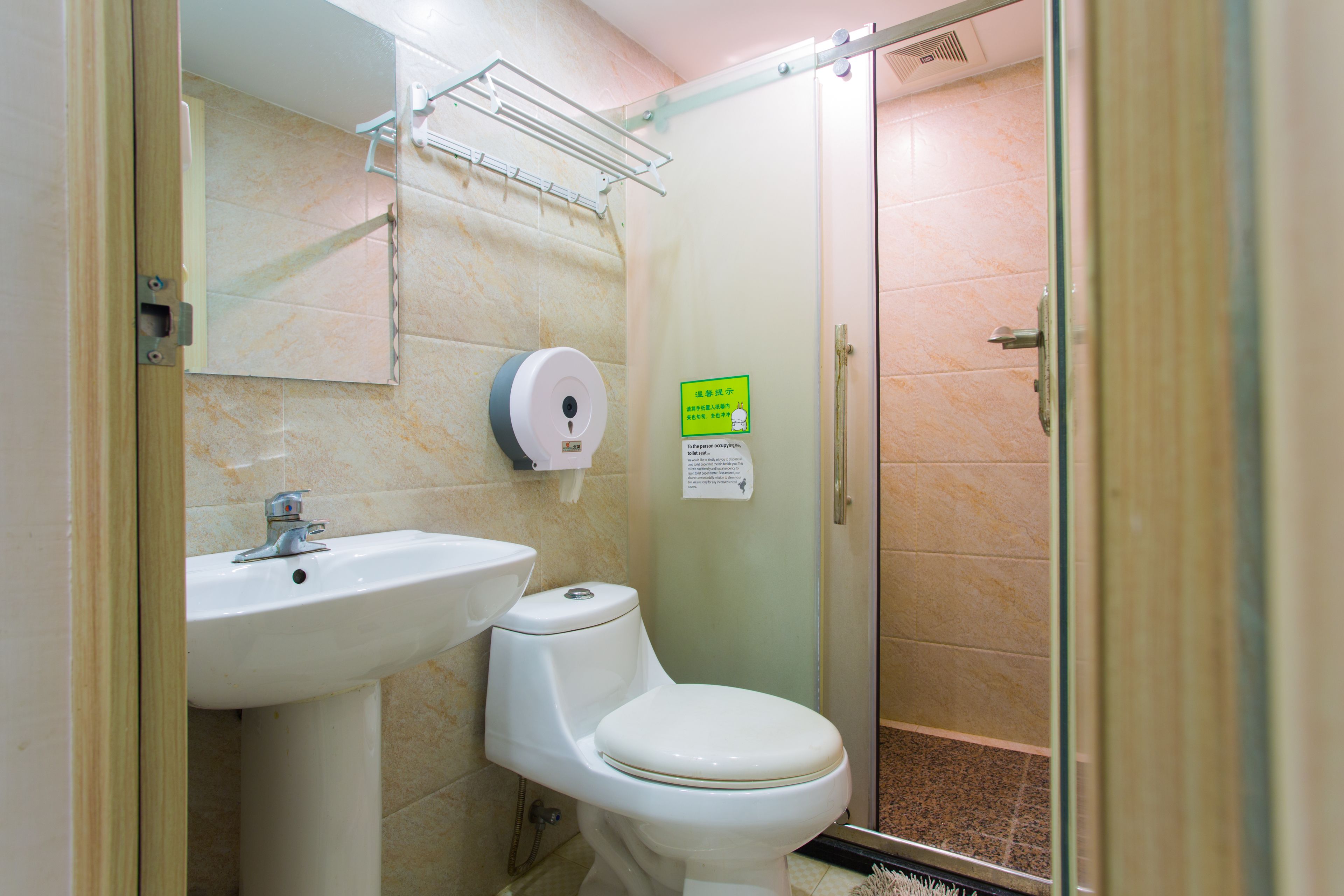 A bathroom with a sink, toilet, and glass shower enclosure.