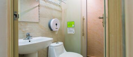 A bathroom with a sink, toilet, and glass shower enclosure.