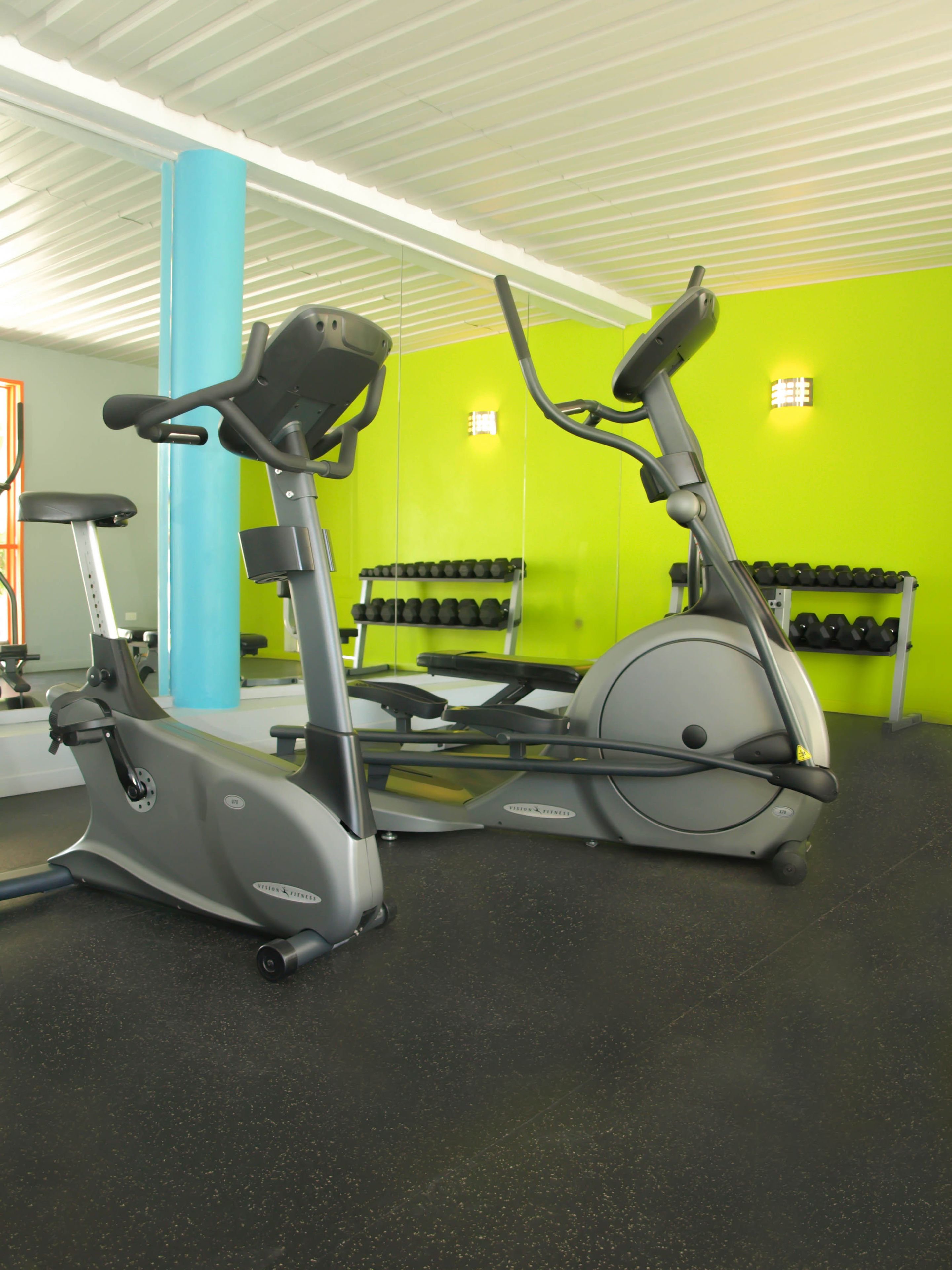 Une salle de sport équipée de vélos d’appartement et d’haltères.