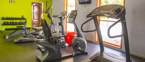 A gym with treadmills, a red exercise ball, and a door leading outside.