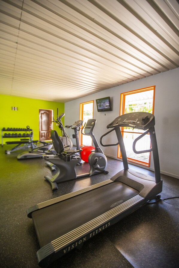 A gym with treadmills, a red exercise ball, and a door leading outside.