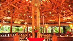 Un restaurant doté d’un plafond et de colonnes en bois, avec des tables et des chaises.