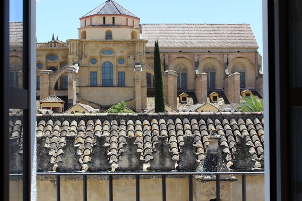 A historic building with a central tower, arched windows, and a tiled roof.