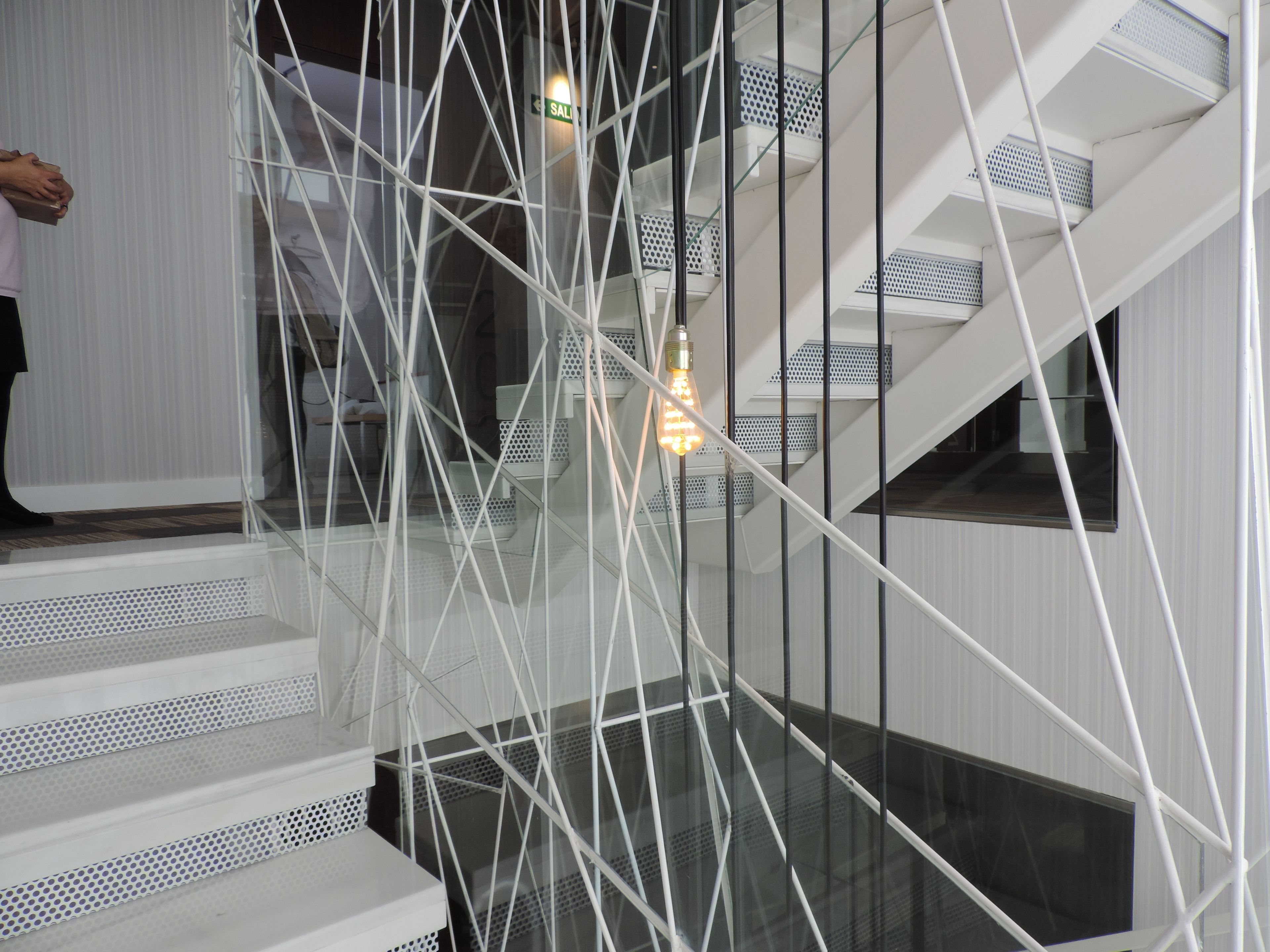 A modern staircase with glass railings and metal supports.