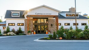 Un hotel con una entrada destacada, fachada de ladrillo y un letrero que dice "CapitalVacations".