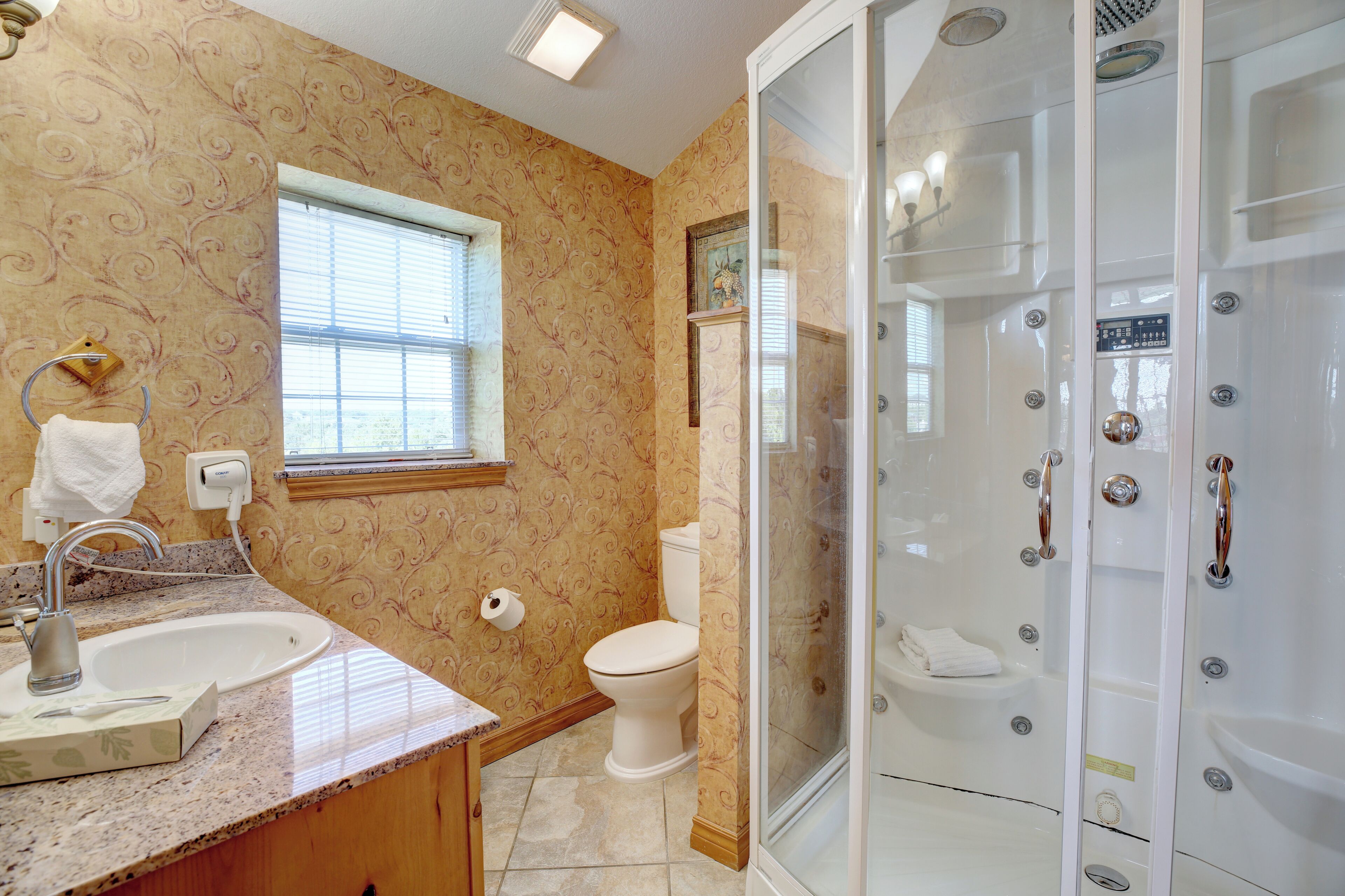 A bathroom with a sink, toilet, and a walk-in shower.