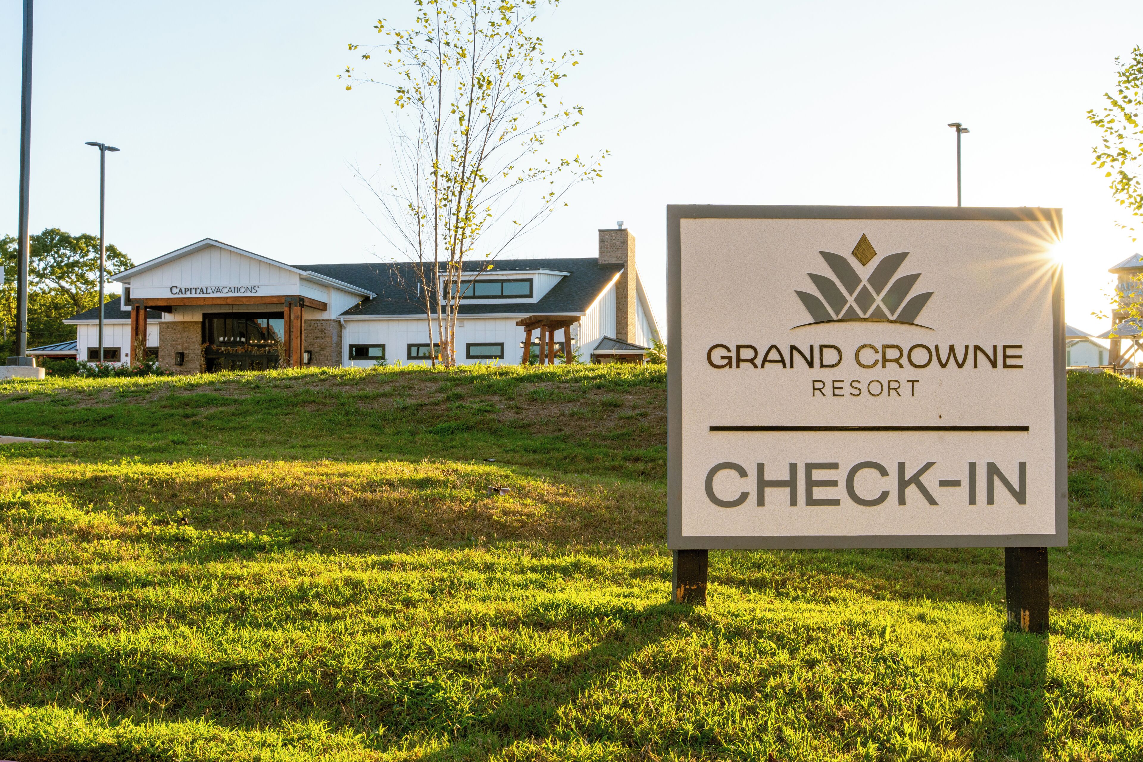 A sign for Grand Crowne Resort with a check-in area.