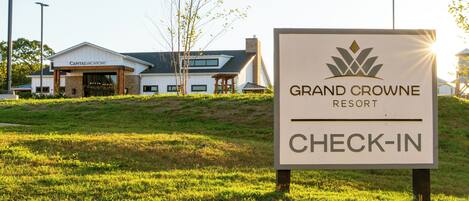 A sign for Grand Crowne Resort with a check-in area.