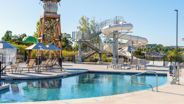 Una piscina con tobogán y torre de salvavidas.