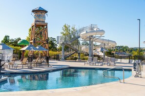 A water park with a pool, a water slide, and a tower structure. - Grand Crowne Resort (Branson)