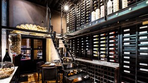 Une cave à vin dotée de sols en bois, d’étagères en métal et d’une grande variété de bouteilles de vin.