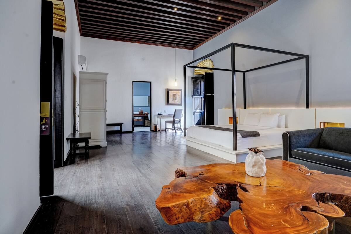 A modern living room with a large wooden coffee table, a sofa, and a minimalist design.
