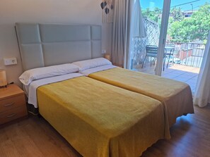 A double bed with a headboard, a bedside table with a lamp, and a view of the outside balcony. - Hotel 139 (Castelldefels)