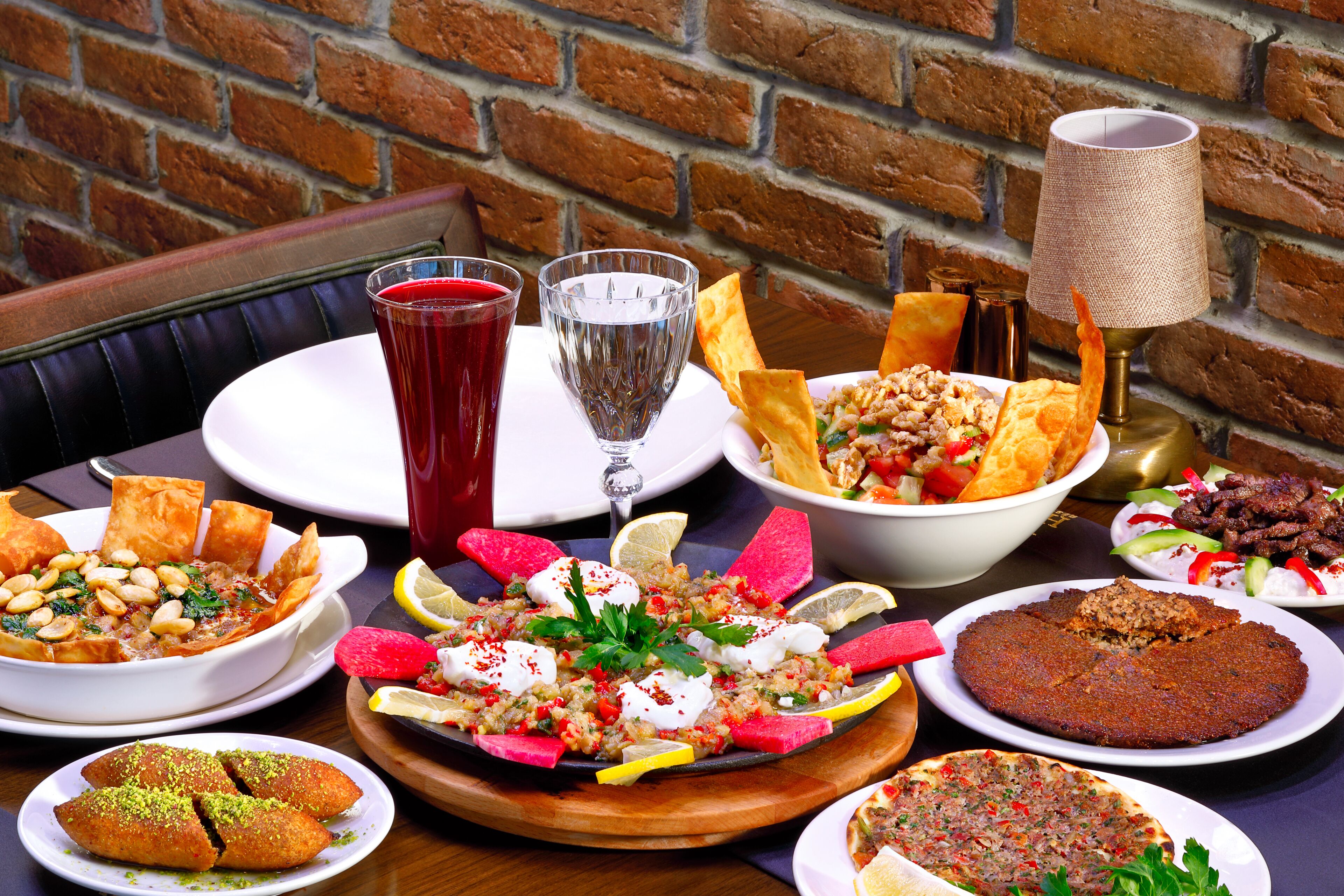 A table with various dishes, drinks, and a lamp.