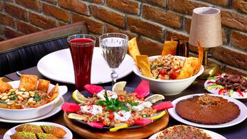 A table with various dishes, drinks, and a lamp.