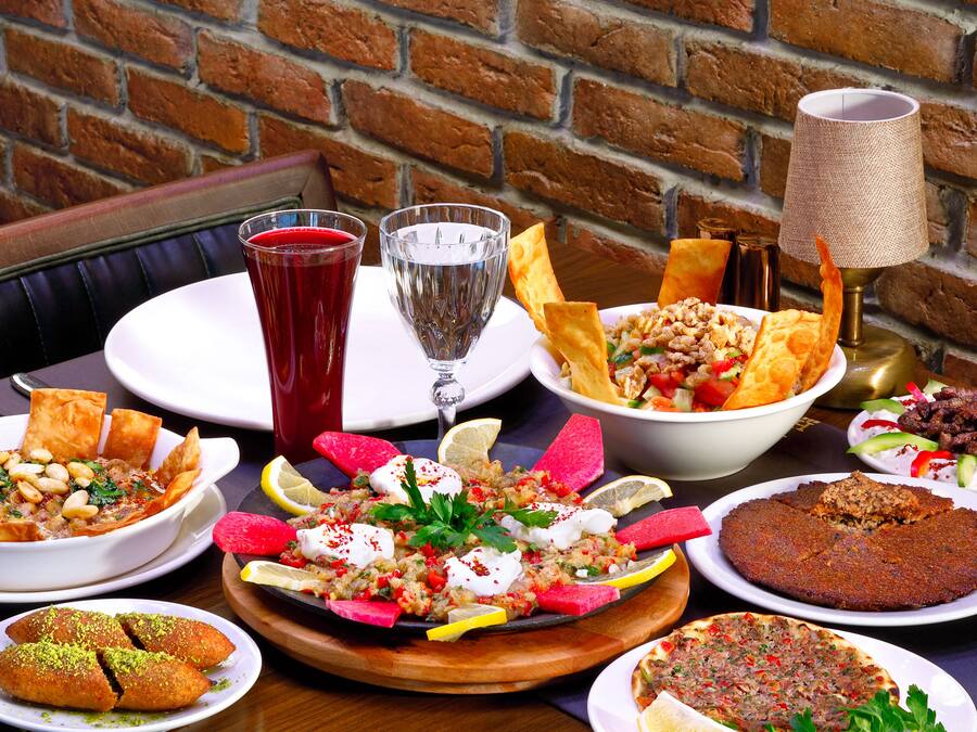 A table with various dishes, drinks, and a lamp.