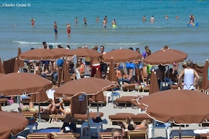 Di pantai, pasir putih, dan handuk pantai