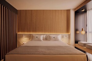 Una habitación de hotel moderna con una cama grande, cabecera de madera, mesitas de noche y una lámpara colgante.