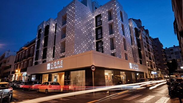 Un hotel moderno con una fachada singular con patrones iluminados.