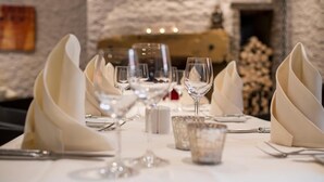 A dining table set with white napkins, clear glassware, and silverware. - Hotel Das Goldene Lamm (Aalen)