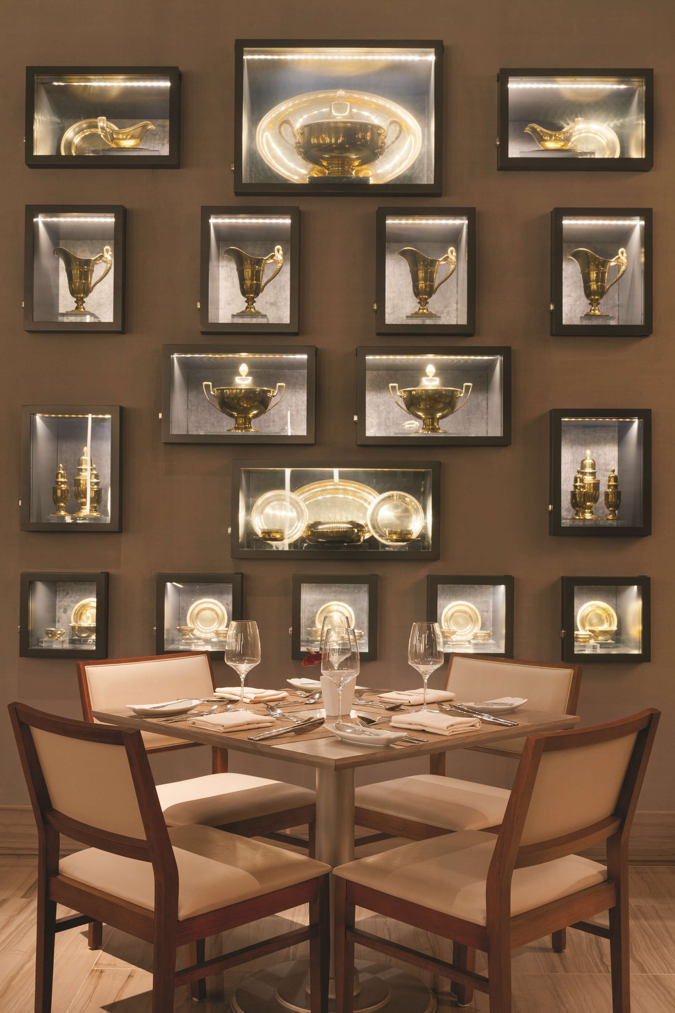 Comedor con una mesa redonda dispuesta para cuatro personas, rodeado de sillas de madera con asientos acolchados.