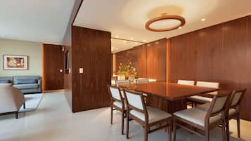Un comedor moderno con una mesa y sillas de madera, un sofá y un jarrón decorativo.