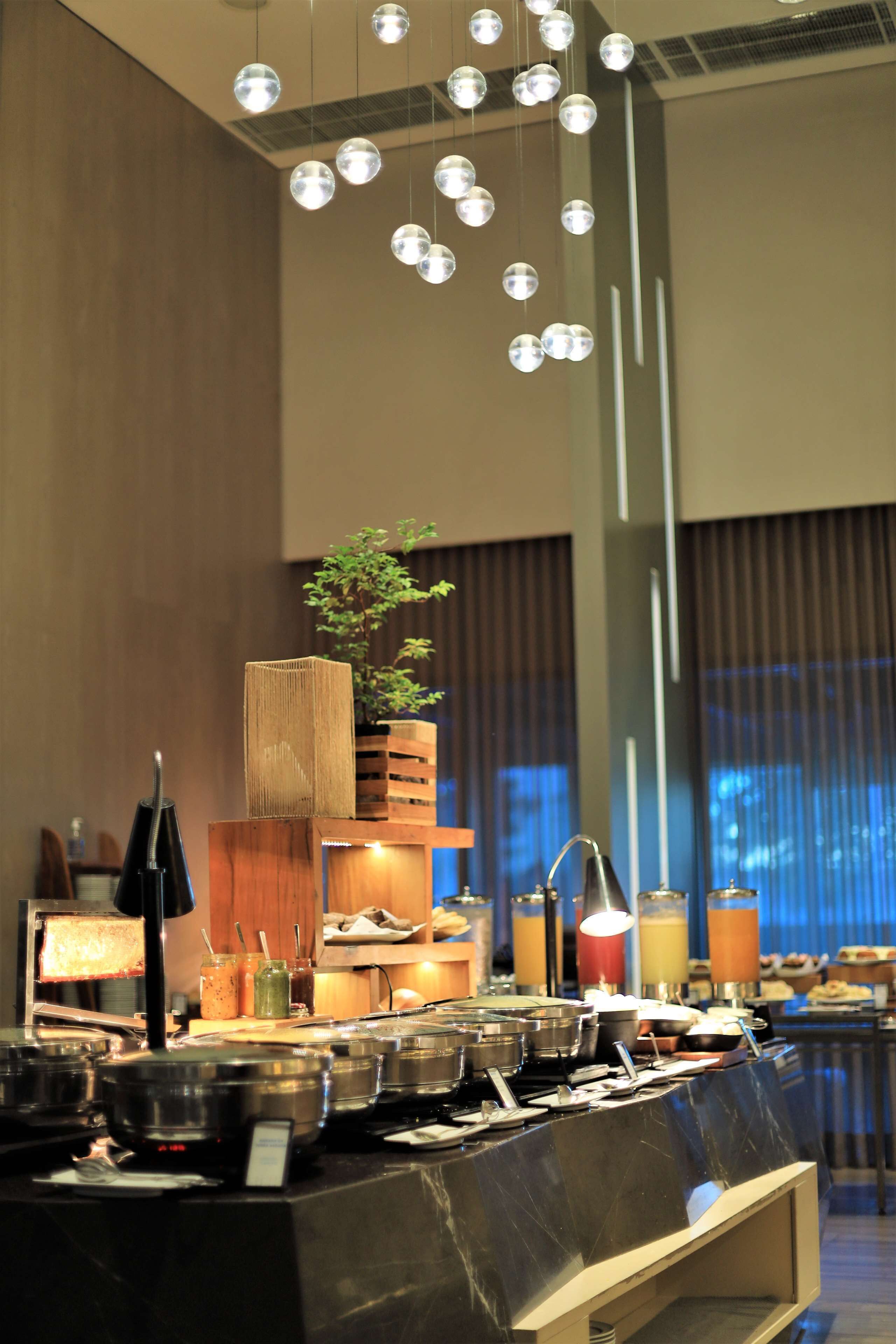 A buffet setup with various food containers, a plant, and a water dispenser.