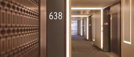 A hallway with a number 638 sign, indicating a room number. The hallway has a modern design with a patterned wall on the left and doors on the right.