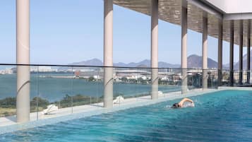 Una piscina al aire libre, sillones reclinables de piscina