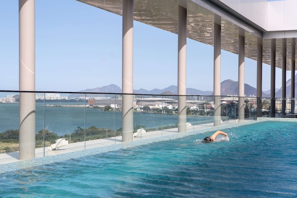 Una piscina al aire libre, sillones reclinables de piscina