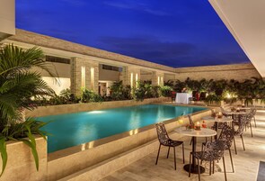 Una piscina al aire libre, sillones reclinables de piscina