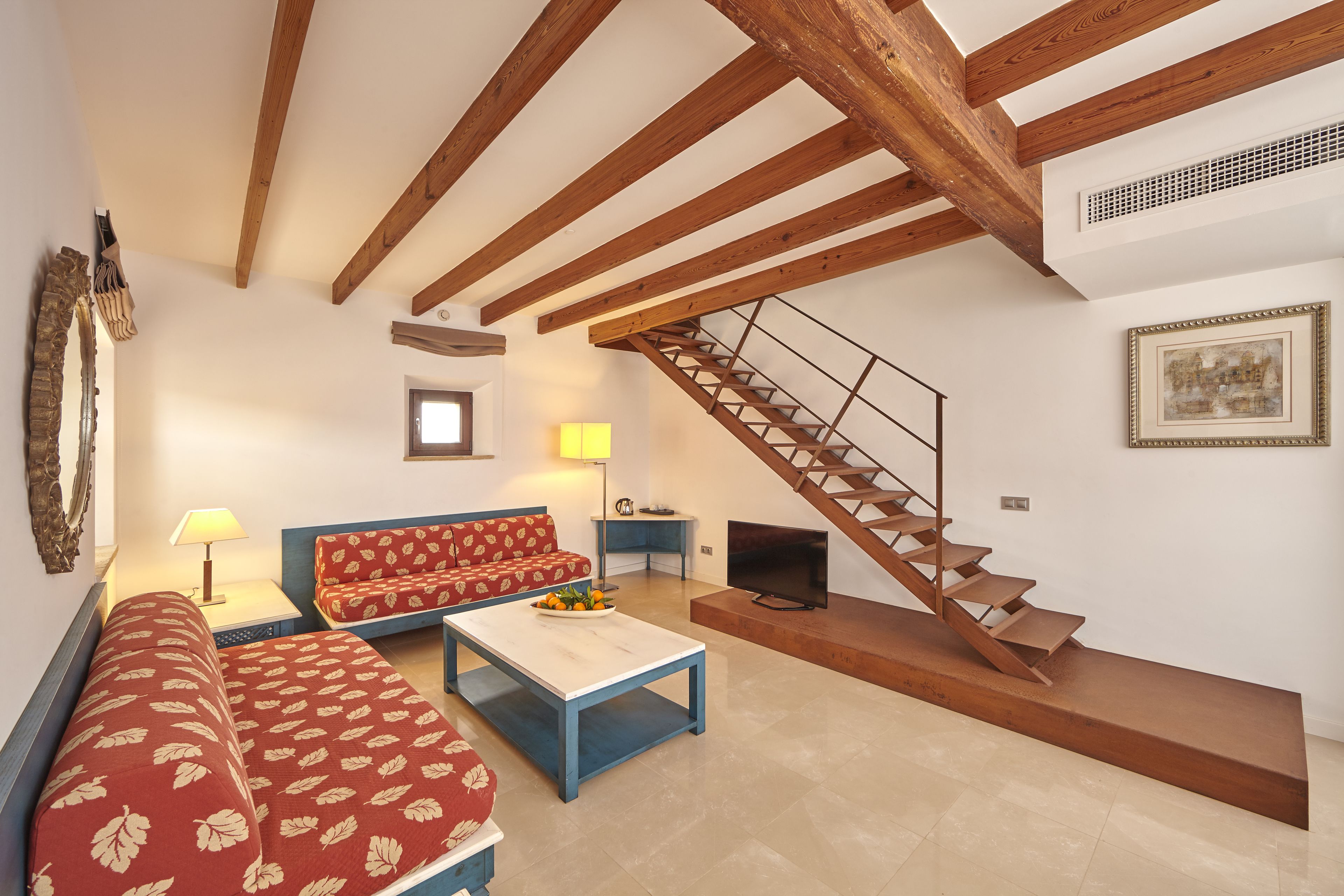 A living room with a sofa, coffee table, and a staircase.