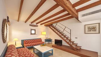 A living room with a sofa, coffee table, and a staircase.