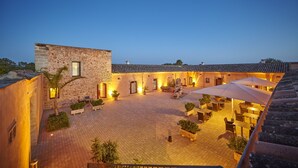 A courtyard with stone buildings, outdoor seating, and potted plants. - Bennoc Petit Hotel (Llucmajor)