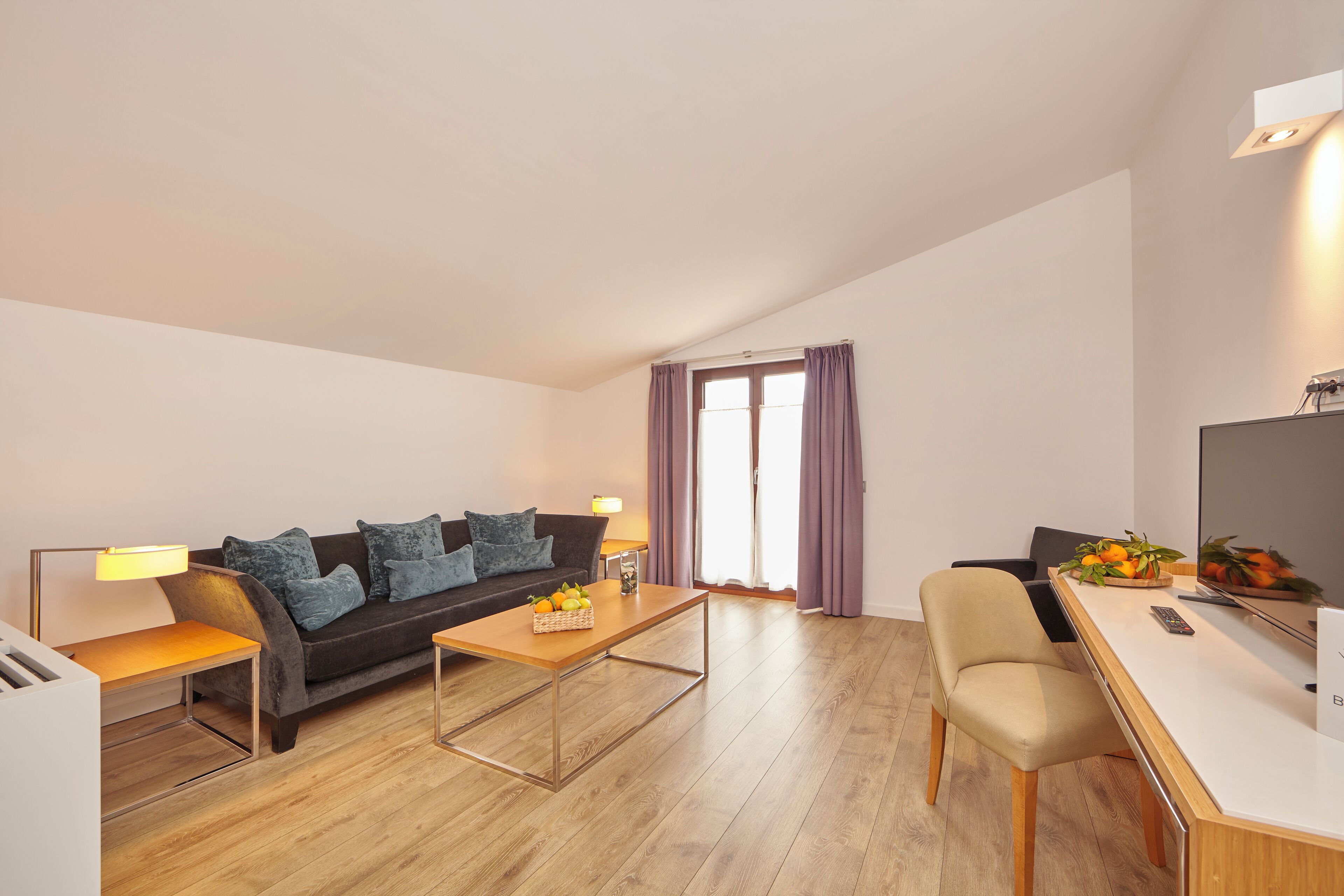 Ein modernes Wohnzimmer mit einer Couch, einem Couchtisch und einem Schreibtisch mit einem Computer.