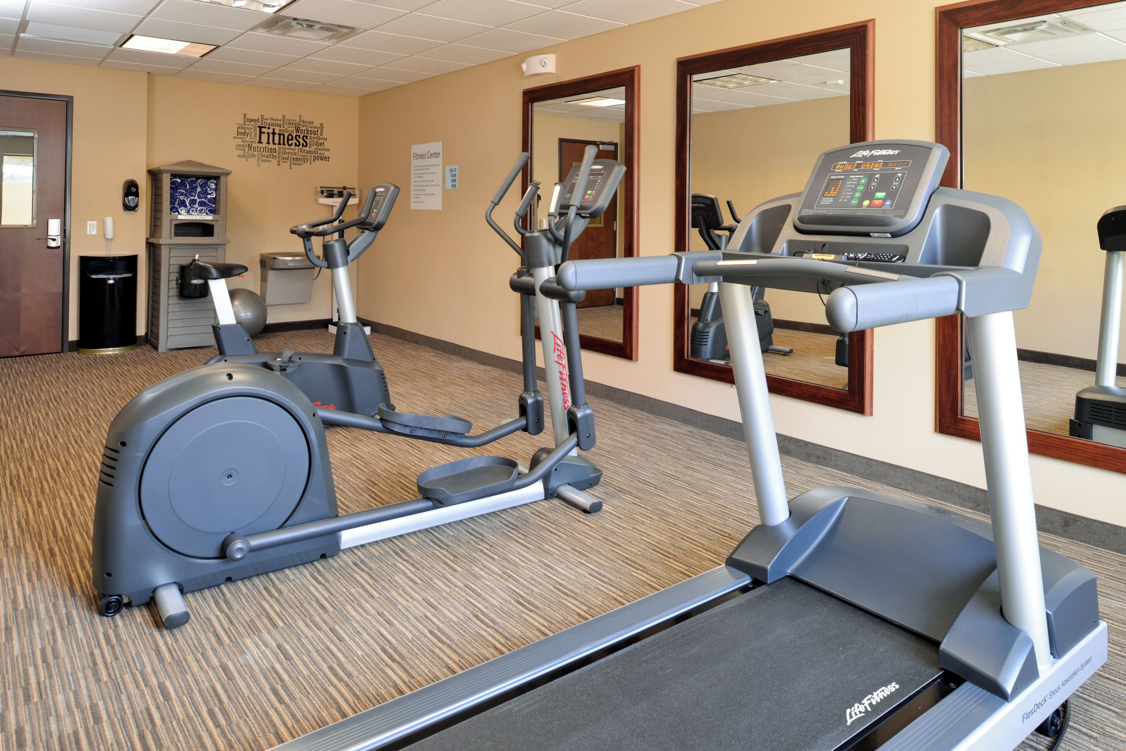 A fitness center with treadmills, elliptical machines, and a stationary bike.